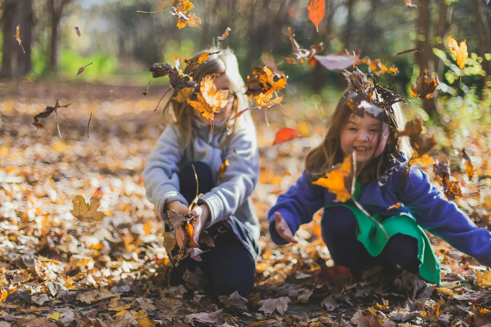 Fillettes qui joue dans les feuilles